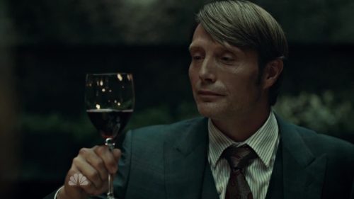 Mads Mikkelson as Hannibal Lecter enjoying wine.